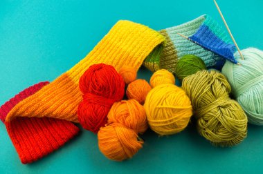 Bir gökkuşağı atkı ve şapka örgü. İğneler örgü yün topları sepetle. Mavi arka plan. En sevdiğim iş bir hobi olduğunu.