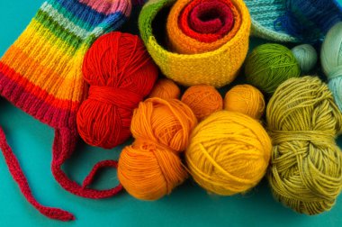 Bir gökkuşağı atkı ve şapka örgü. İğneler örgü yün topları sepetle. Mavi arka plan. En sevdiğim iş bir hobi olduğunu.