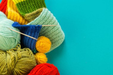 Bir gökkuşağı atkı ve şapka örgü. İğneler örgü yün topları sepetle. Mavi arka plan. En sevdiğim iş bir hobi olduğunu.