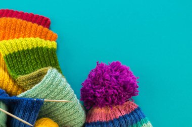 Bir gökkuşağı atkı ve şapka örgü. İğneler örgü yün topları sepetle. Mavi arka plan. En sevdiğim iş bir hobi olduğunu.