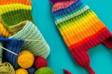 Bir gökkuşağı atkı ve şapka örgü. İğneler örgü yün topları sepetle. Mavi arka plan. En sevdiğim iş bir hobi olduğunu.