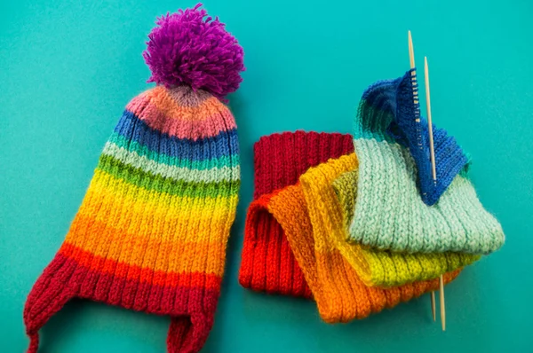 虹のスカーフと帽子を編んでいます 編み物 羊毛のボールとバスケット 青色の背景色 好きな仕事は趣味 — ストック写真