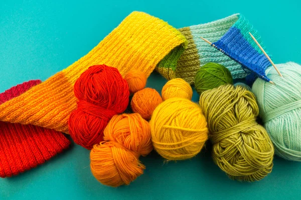虹のスカーフと帽子を編んでいます 編み物 羊毛のボールとバスケット 青色の背景色 好きな仕事は趣味 — ストック写真