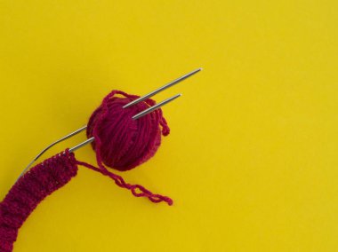 Bir sürü top sarı bir arka plan üzerinde gökkuşağı renkli örgü için. En sevdiği hobi. Şapka örgü işlemi.
