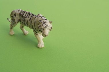 Bir çocuk oyuncak bir kaplan hayvandır. Oyun için plastik heykelcik. Yeşil arka plan. Çiftlik ve Hayvanat Bahçesi.