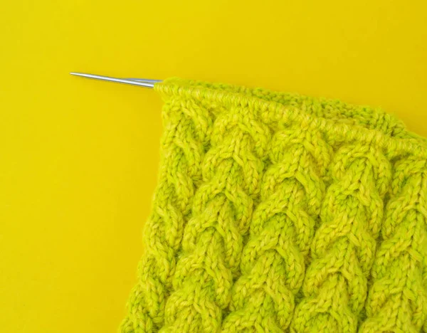 Yellow and green coats of wool lie on the table. Favorite hobby is knitting. Home cosiness.
