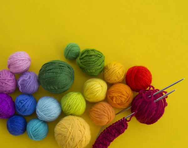 在黄色背景上编织彩虹颜色的球很多 最喜欢的嗜好 针织帽工艺 — 图库照片