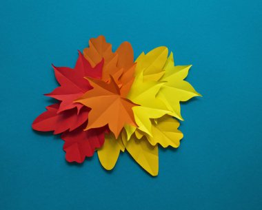 Kağıt sonbahar yaprakları bir daire içinde. Kırmızı, sarı ve turuncu yaprak. Kayıt için bir yer. Mavi arka plan.