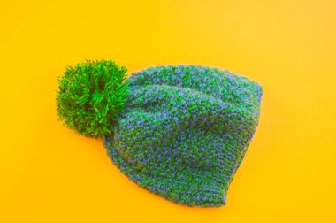 Yün sarı bir arka plan üzerinde yeşil-mavi kap. Uzay kopyalayın. Yukarıdan görüntülemek.