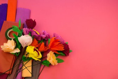 Kapkacak ve aletleri krep kağıt çiçek, pembe arka plan yapmak için. Cosmos çiçek buketi