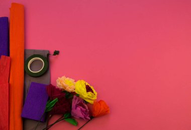 Kapkacak ve aletleri krep kağıt çiçek, pembe arka plan yapmak için. Cosmos çiçek buketi