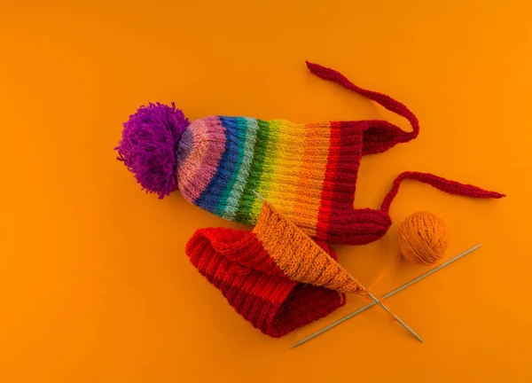 Regenbogenkappe Aus Wolle Auf Orangefarbenem Hintergrund Kopierraum Blick Von Oben — Stockfoto