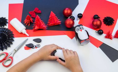 Çocuk ana sınıfı el yapımı kağıt penguen. Bir çocuğun eli. Bebek Handmade.Creativity.
