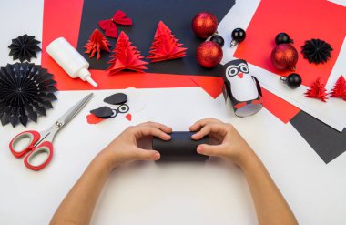 Çocuk ana sınıfı el yapımı kağıt penguen. Bir çocuğun eli. Bebek Handmade.Creativity.