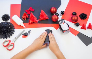 Çocuk ana sınıfı el yapımı kağıt penguen. Bir çocuğun eli. Bebek Handmade.Creativity.