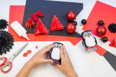 Çocuk ana sınıfı el yapımı kağıt penguen. Bir çocuğun eli. Bebek Handmade.Creativity.