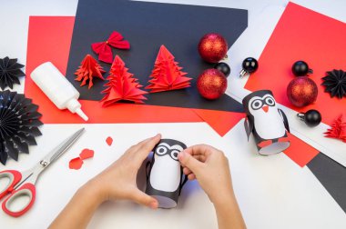 Çocuk ana sınıfı el yapımı kağıt penguen. Bir çocuğun eli. Bebek Handmade.Creativity.