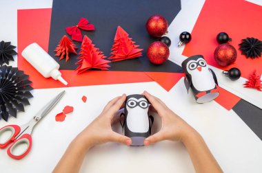 Çocuk ana sınıfı el yapımı kağıt penguen. Bir çocuğun eli. Bebek Handmade.Creativity.