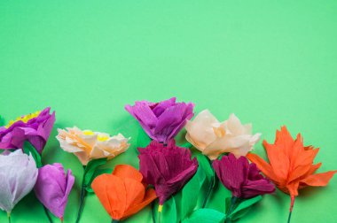 Kapkacak ve aletleri krep kağıt çiçekler üzerinde yeşil arka plan yapmak için. Cosmos çiçek buketi