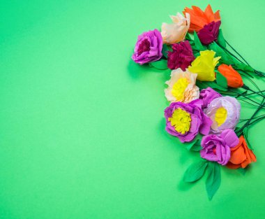 Kapkacak ve aletleri krep kağıt çiçekler üzerinde yeşil arka plan yapmak için. Cosmos çiçek buketi