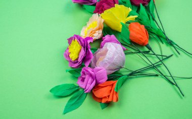 Kapkacak ve aletleri krep kağıt çiçekler üzerinde yeşil arka plan yapmak için. Cosmos çiçek buketi