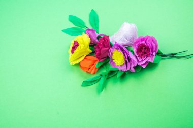 Kapkacak ve aletleri krep kağıt çiçekler üzerinde yeşil arka plan yapmak için. Cosmos çiçek buketi