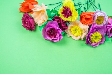 Kapkacak ve aletleri krep kağıt çiçekler üzerinde yeşil arka plan yapmak için. Cosmos çiçek buketi
