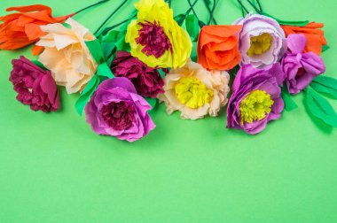 Kapkacak ve aletleri krep kağıt çiçekler üzerinde yeşil arka plan yapmak için. Cosmos çiçek buketi