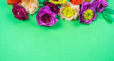 Kapkacak ve aletleri krep kağıt çiçekler üzerinde yeşil arka plan yapmak için. Cosmos çiçek buketi