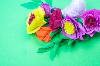 Kapkacak ve aletleri krep kağıt çiçekler üzerinde yeşil arka plan yapmak için. Cosmos çiçek buketi