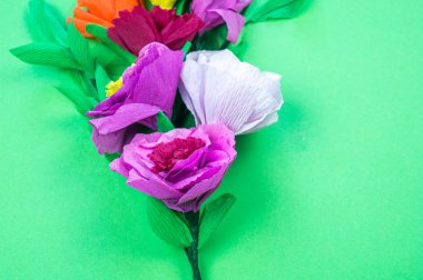 Kapkacak ve aletleri krep kağıt çiçekler üzerinde yeşil arka plan yapmak için. Cosmos çiçek buketi