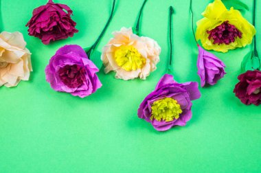 Kapkacak ve aletleri krep kağıt çiçekler üzerinde yeşil arka plan yapmak için. Cosmos çiçek buketi