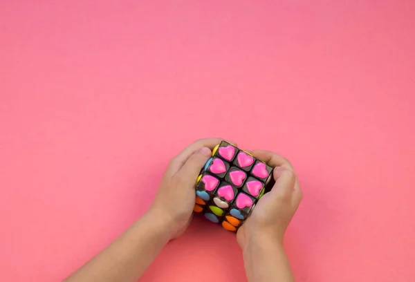 Çocuk Elinde Rubik Küp Bulmaca Çözün Pembe Bir Arka Plan — Stok fotoğraf