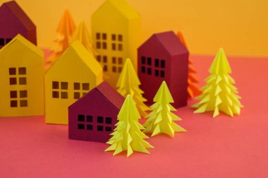 Noel orman kağıttan yapılmış. Bir ev ve bir Noel ağacı. Kartopu. Pembe ve sarı renkler.