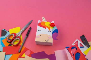 Pembe bir arka plan üzerinde Paper tek boynuzlu at. Ana sınıfı el yapımı. Büyülü bir hayvan. Yaratıcılık ve araçlar için malzemeler.