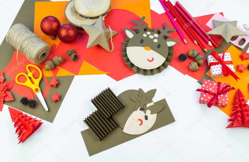 Baby hand making deer out of paper. Christmas crafts decoration home decor. Creativity for a child.