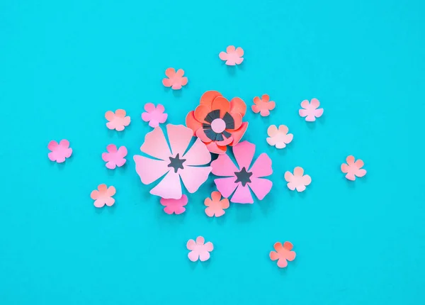 Flower and leaves made of paper on a turquoise background. Handwork, favorite hobby. Pink black and blue color.