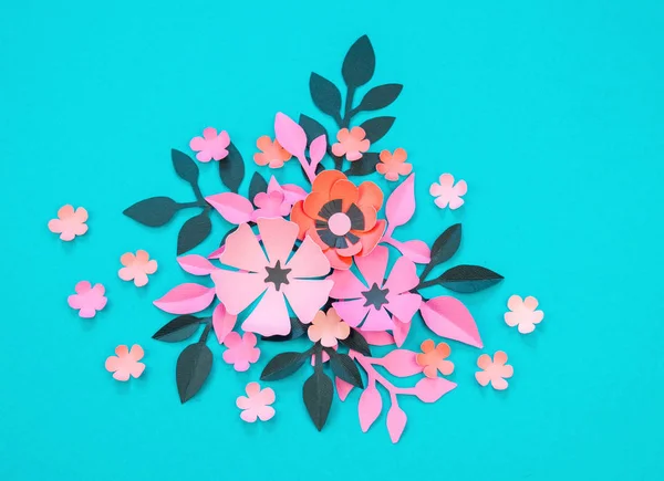 Flower and leaves made of paper on a turquoise background. Handwork, favorite hobby. Pink black and blue color.
