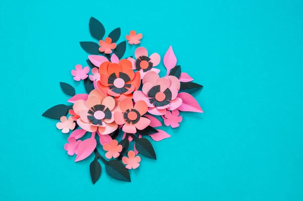 Flower and leaves made of paper on a turquoise background. Handwork, favorite hobby. Pink black and blue color.
