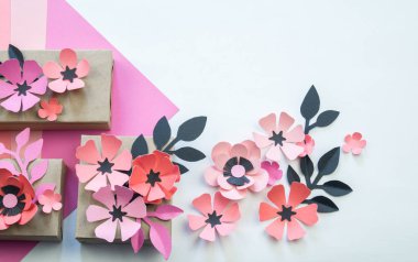 Kurdela ve çiçekler ile şenlikli bir kutu ambalaj. Çiçek kağıttan yapılmış. En sevdiği hobi. Yukarıdan görüntülemek.