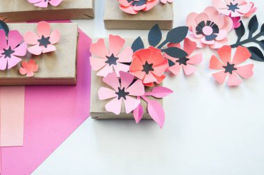 Kurdela ve çiçekler ile şenlikli bir kutu ambalaj. Çiçek kağıttan yapılmış. En sevdiği hobi. Yukarıdan görüntülemek.