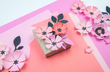 Kurdela ve çiçekler ile şenlikli bir kutu ambalaj. Çiçek kağıttan yapılmış. En sevdiği hobi. Yukarıdan görüntülemek.