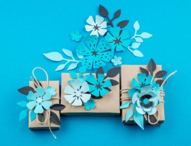 Hediye kutusu craft kağıt mavi arka planda sarılmış. Sakura çiçek kağıt origami yaptı. Hediye.