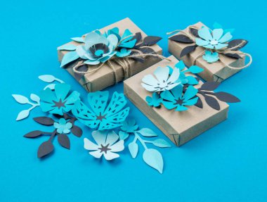 Hediye kutusu craft kağıt mavi arka planda sarılmış. Sakura çiçek kağıt origami yaptı. Hediye.