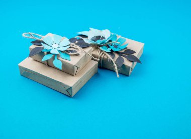 Hediye kutusu craft kağıt mavi arka planda sarılmış. Sakura çiçek kağıt origami yaptı. Hediye.