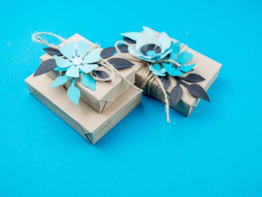Hediye kutusu craft kağıt mavi arka planda sarılmış. Sakura çiçek kağıt origami yaptı. Hediye.