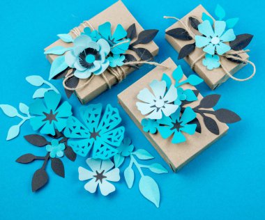 Hediye kutusu craft kağıt mavi arka planda sarılmış. Sakura çiçek kağıt origami yaptı. Hediye.