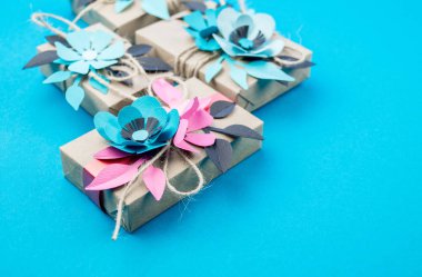 Hediye kutusu craft kağıt mavi arka planda sarılmış. Sakura çiçek kağıt origami yaptı. Hediye.