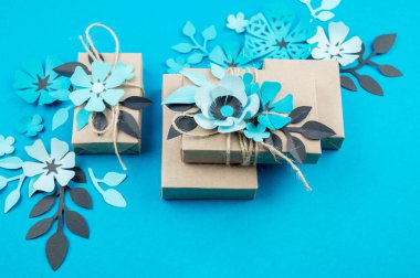 Hediye kutusu craft kağıt mavi arka planda sarılmış. Sakura çiçek kağıt origami yaptı. Hediye.