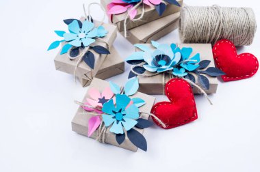 Hediye kutusu Kraft Kağıt beyaz bir arka plan üzerinde sarılı. Kağıt çiçek ve şerit. Kırmızı kalp. Anneler günü tatil ve Sevgililer günü. Ambalaj.